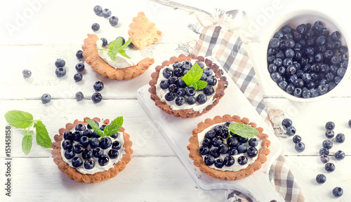Blueberry tarts on a white wooden table.
