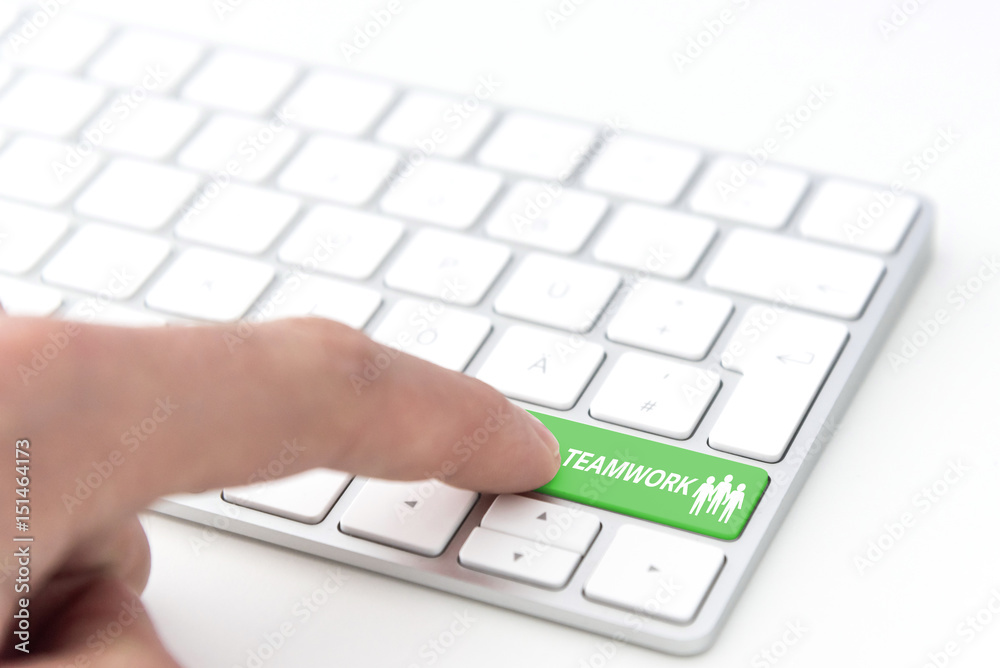 finger pressing a green key labeled TEAMWORK with symbol on a computer keyboard concept finger pressing a green key labeled TEAMWORK with symbol on a computer keyboard concept