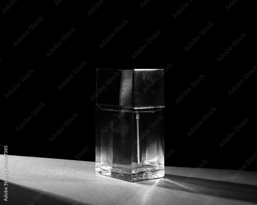Bottle of modern male perfume on dark background Bottle of modern male perfume on dark background