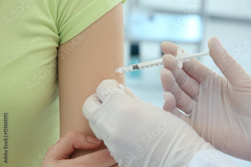 Doctor vaccinating patient in clinic, closeup