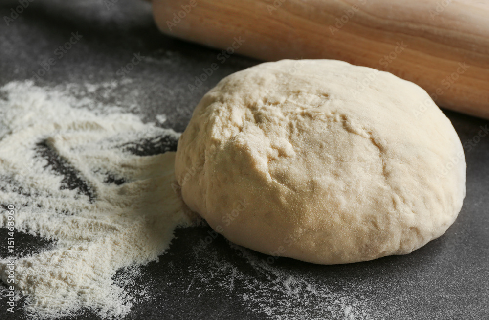 Raw dough on dark textured table, closeup Raw dough on dark textured table, closeup
