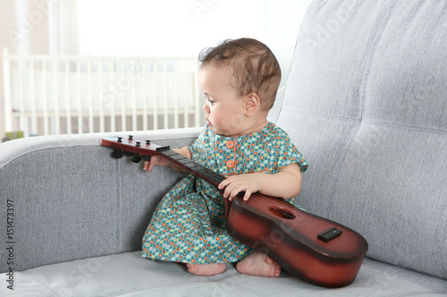 Cute little baby with guita...
