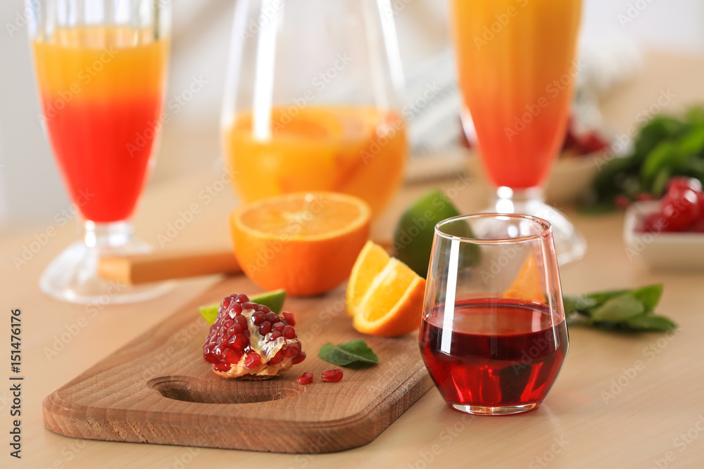 Glasses of Tequila Sunrise cocktail with ingredients on kitchen table Glasses of Tequila Sunrise cocktail with ingredients on kitchen table