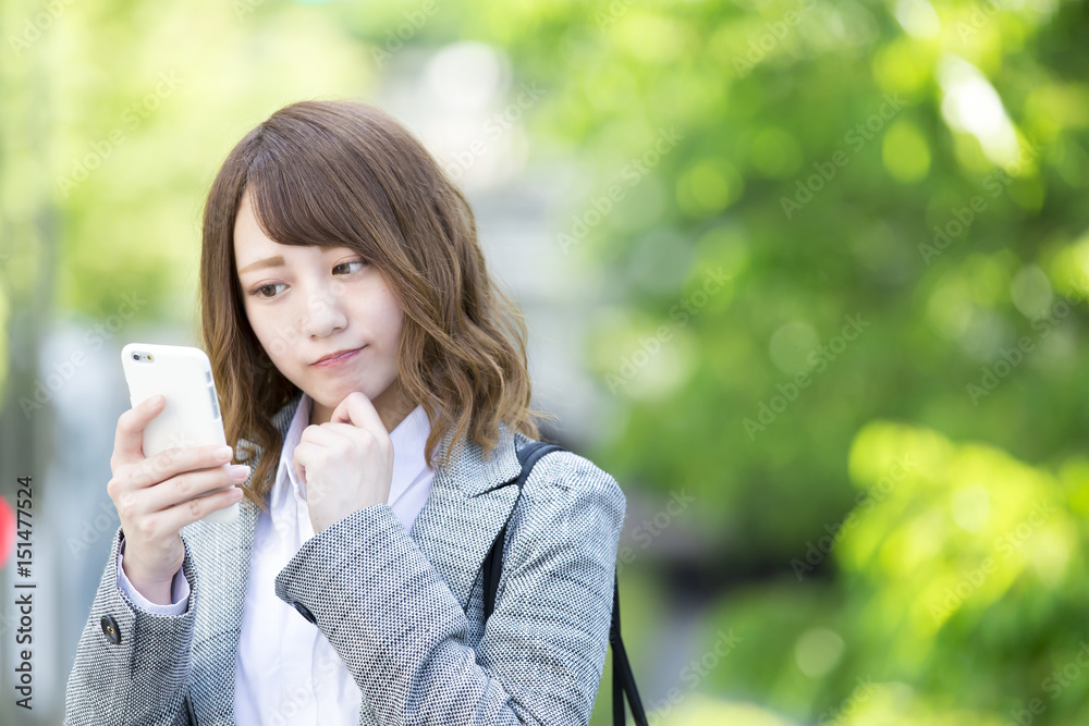 スマホを見て困る女性