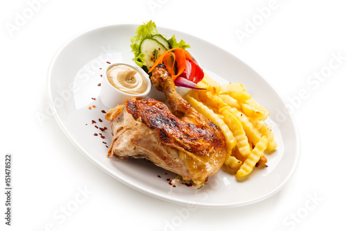 Roast chicken leg with french fries on white background