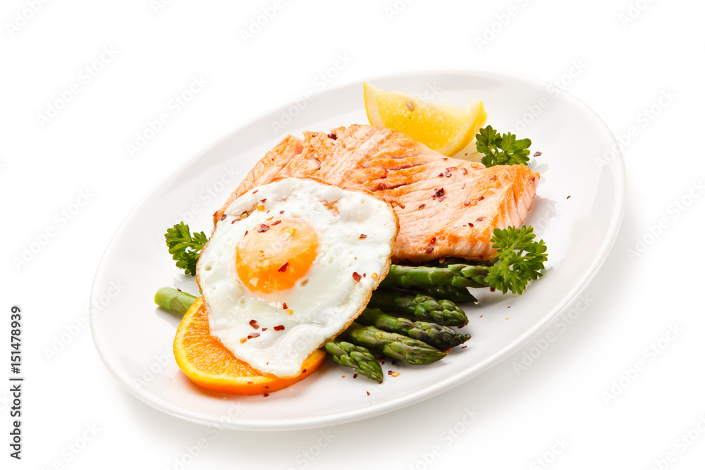 Griilled salmon with asparagus and fried egg on white background Griilled salmon with asparagus and fried egg on white background