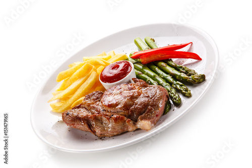 Grilled steak with french fries and asparagus on white background