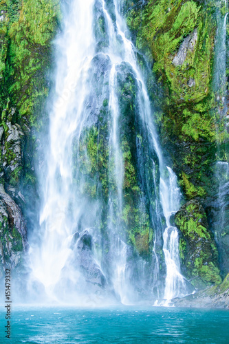 Fototapeta Naklejka Na Ścianę i Meble -  Waterfall with fluffy steam fall on the sea, Milford Sound, Southern Island, New Zealand