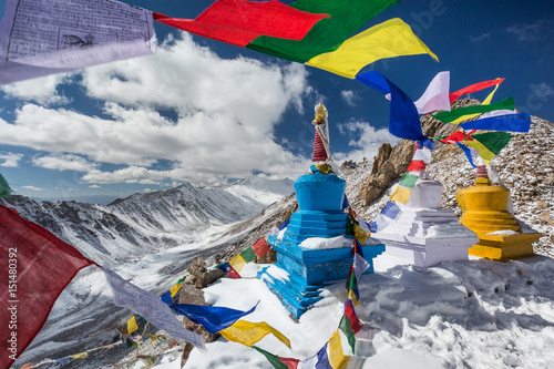 Colourful Buddhist religious stupas and prayer flags at Khardung La pass, the highest (5,359 m, 17,582 ft) motorable pass on the world. Ladakh, Jammu and Kashmir, India