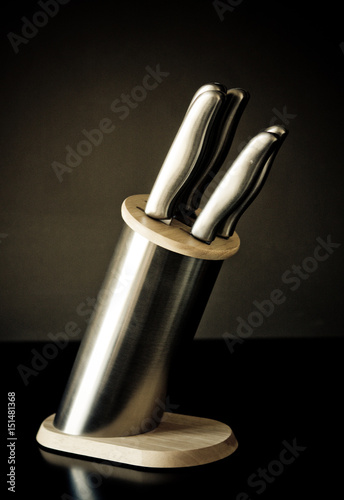 Kitchen knives set against dark brown background