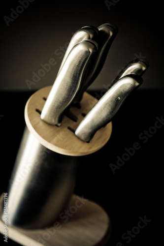 Kitchen knives set against dark brown background