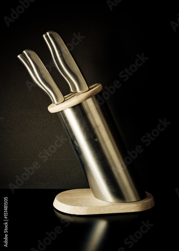 Kitchen knives set against dark brown background