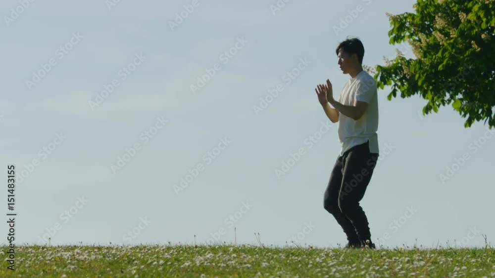 Close up of man doing tai chi outdoors in the countryside