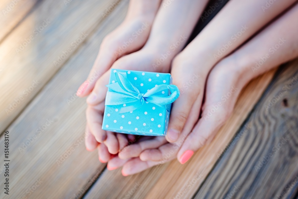 Child and mother's hands holding a gift