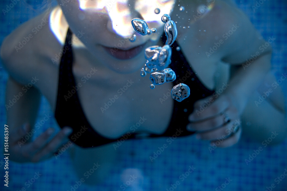 Teen girl underwater at the pool on a summer day Stock Photo