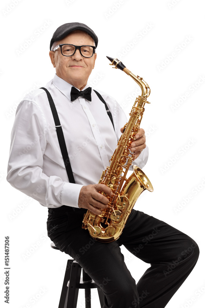 Naklejka premium Mature jazz musician with a saxophone sitting on a chair