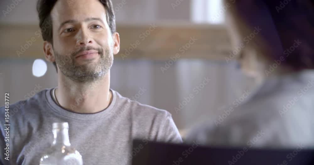 Brunette man talking detail. Four happy real candid friends enjoy having lunch or dinner together at home or restaurant. 4k video Brunette man talking detail. Four happy real candid friends enjoy having lunch or dinner together at home or restaurant. 4k video