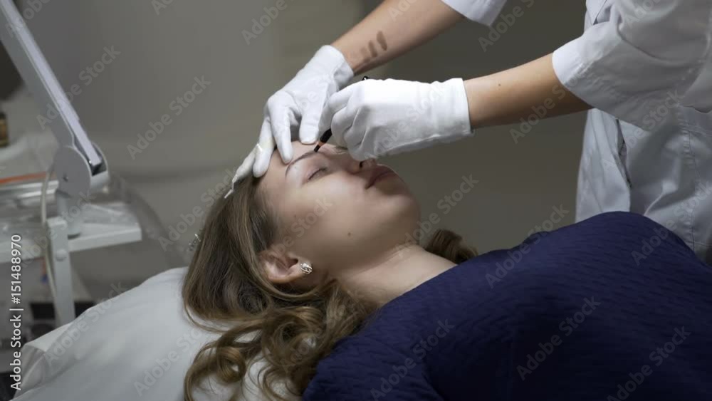 Cosmetology. A girl at a reception in a beauty salon. Eyebrow correction. Cosmetology. A girl at a reception in a beauty salon. Eyebrow correction.