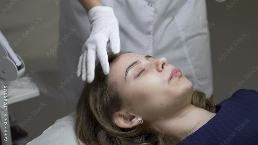 Cosmetology. A girl at a reception in a beauty salon. Eyebrow correction. Cosmetology. A girl at a reception in a beauty salon. Eyebrow correction.