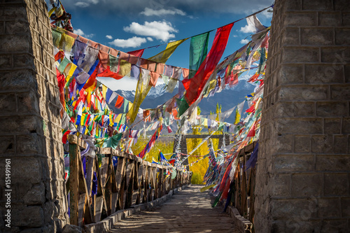 Colourful Buddhist prayer flags on a bridge above Indus river in the Himalayan mountain, Leh, Ladakh, India