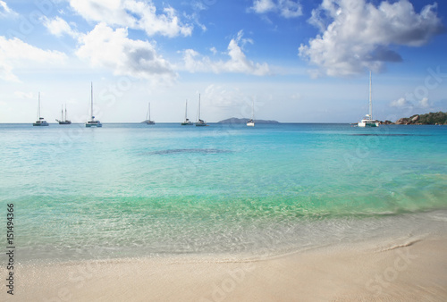 White yachts in the clear waters of Anse Lazio