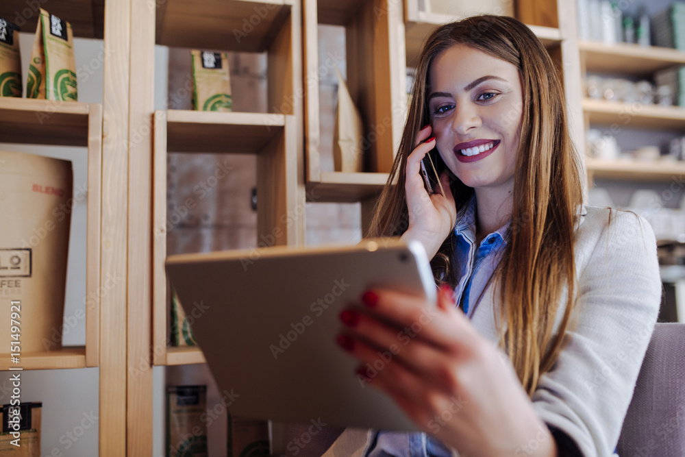 Beautiful Young Woman Talking on Phone and Using Tablet Beautiful Young Woman Talking on Phone and Using Tablet