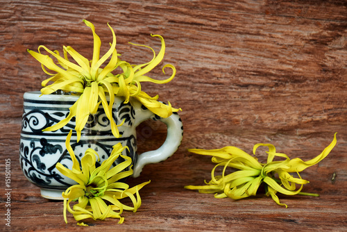 ylang ylang in cup of coffee on the wooden