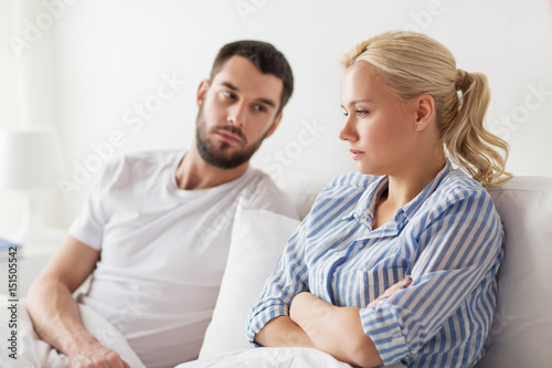 unhappy couple having conflict in bed at home