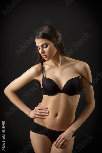 beautiful sexy brunette woman posing in black lingerie on black background. Seductive and attractive slim shapely body  © producer