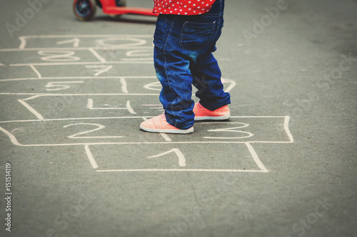 little girl playing hopscotch at playground