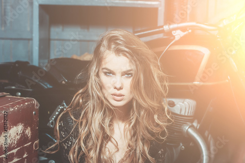 Sexy fashion model sitting at metallized motorcycle