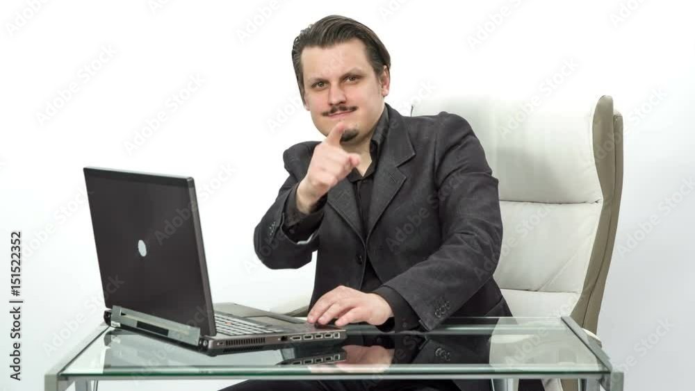 A young man shows a fist of power and then he points at the camera. He looks happy.