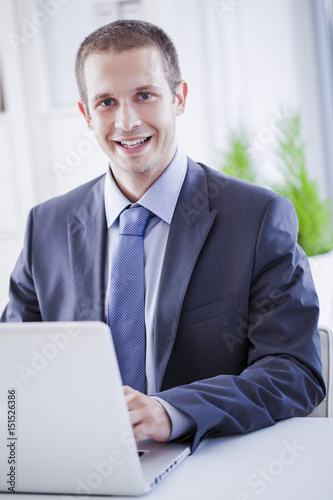 Smiling Businessman Sitting at His Laptop © LStockStudio