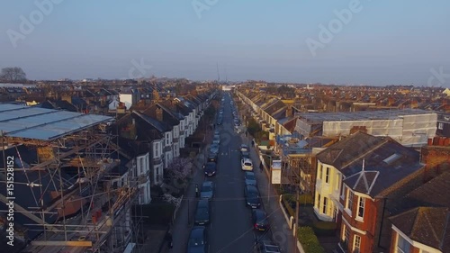 Flying above London surburban houses and apartments aerial view at dawn on sunny day