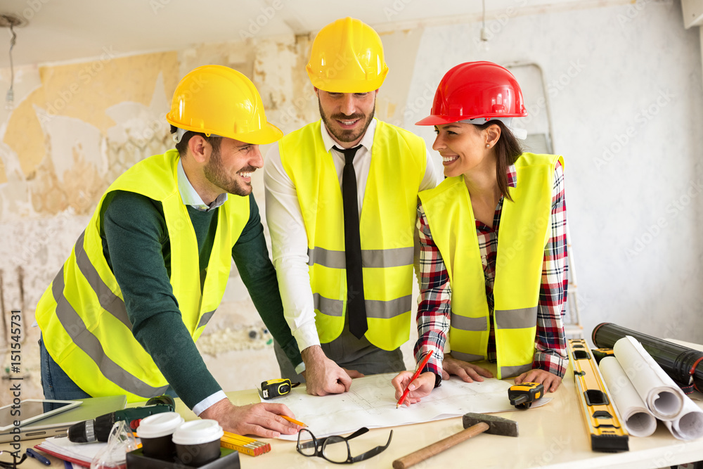 Three arhitects working together on construction site project Three arhitects working together on construction site project