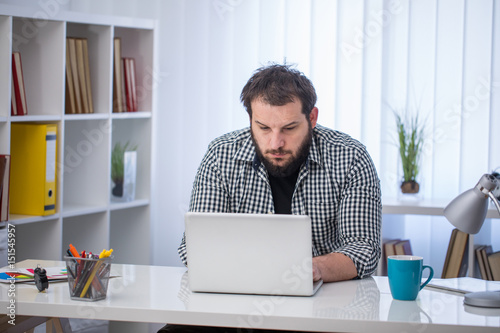 Handsome businessman working with laptop in office