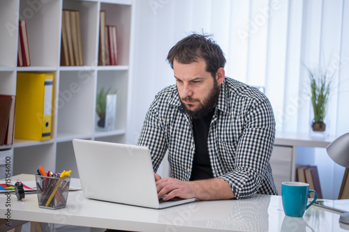 Handsome businessman working with laptop in office