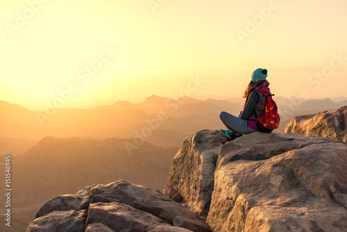 girl looking at the sunrise over the mountains