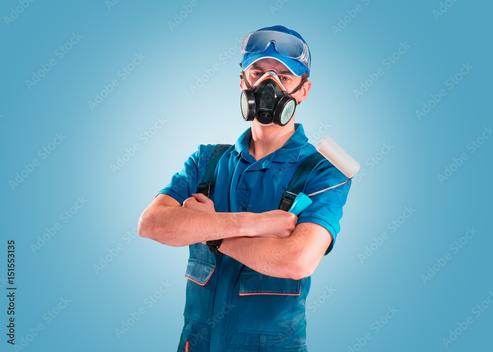 Building painter in protective mask and glasses on a blu background. Painting concept.