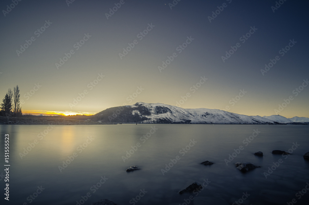 Fototapeta premium Beautiful dusk hour at Lake Tekapo, New Zealand. During winter time, mountain at the back are covered with snow and make the view more beautiful.