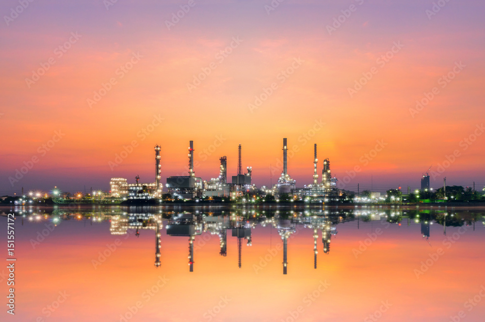 oil refinery industry at morning golden hour with water reflection.