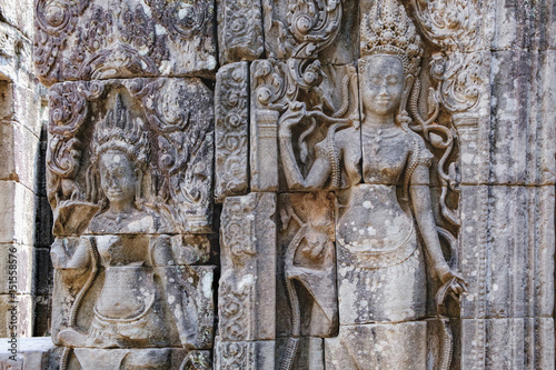 Beautiful Cambodian women dancing Apsaras. Old Khmer art carvings on the wall of Prasat Bayon, the central temple of Angkor Thom Complex, Siem Reap, Cambodia.