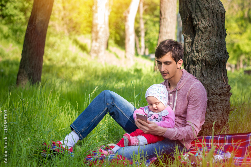 Young father with baby outdoors in park Young father with baby outdoors in park