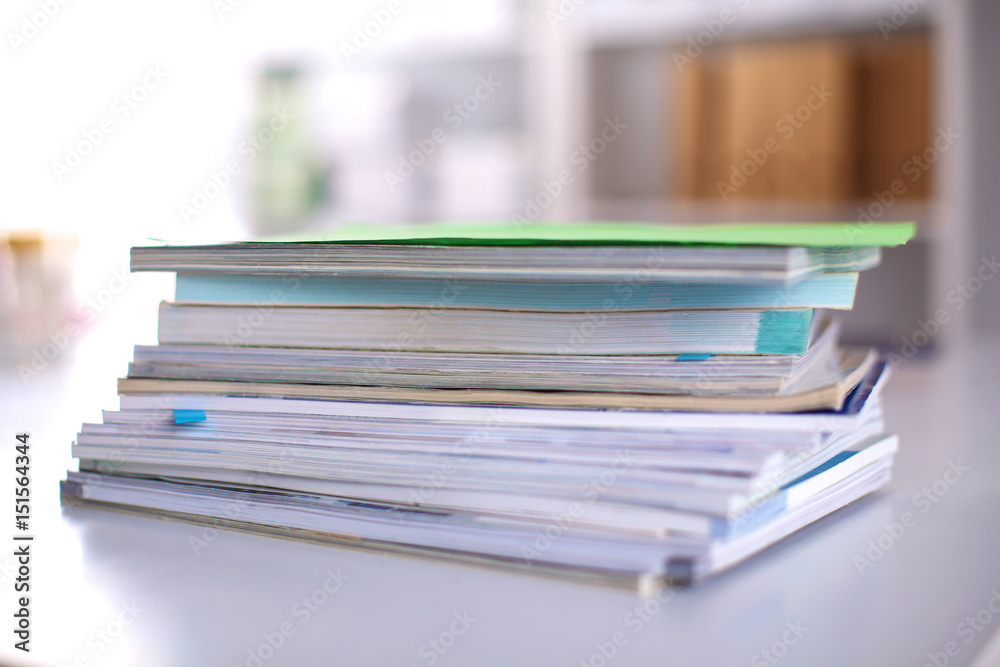 A stack of documentation is on the desktop in the office A stack of documentation is on the desktop in the office