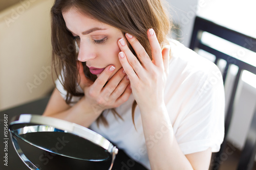 Woman sitting by the mirror photo