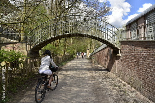 Cycliste vers l'arche-passerelle sur la Promenade Verte du sud de Bruxelles