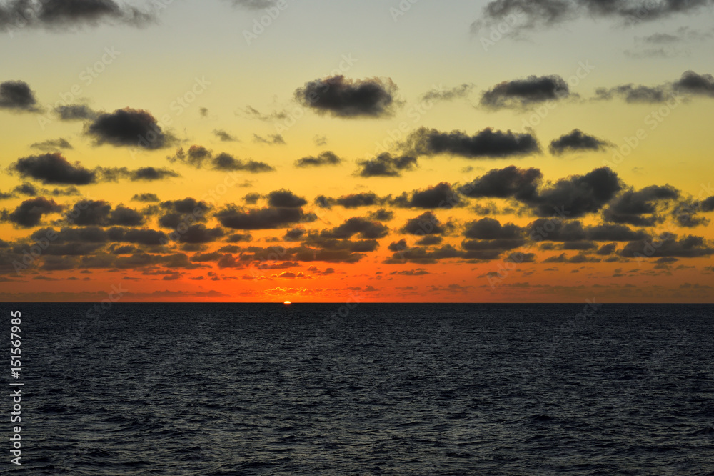 Sunset in ocean: dramatic clouds