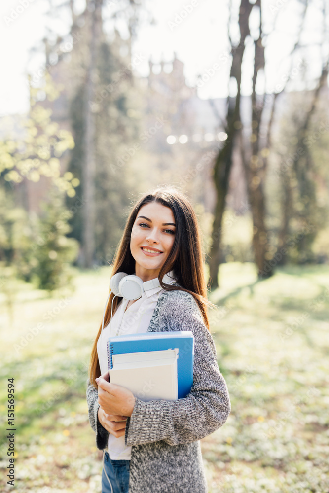 University college student girl looking happy smiling with book or notebook in campus park. Caucasian young woman female model. University college student girl looking happy smiling with book or notebook in campus park. Caucasian young woman female model.