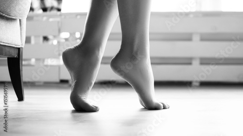 female soigne beautiful feet on tiptoe on floor photo