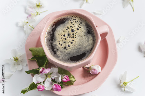 coffee concept/pink cup of coffee and apple flowers on white background